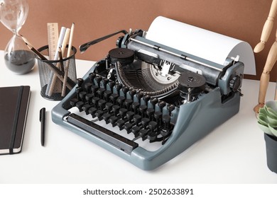 Vintage typewriter with wooden mannequin, pencil holder and hourglass on white table near brown wall - Powered by Shutterstock