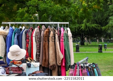 vintage used clothes and new dresses in the stall at the flea market
