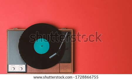 Vintage vinyl player and turnable on a red background. Entertainment 70s. Listen to music. Top view.