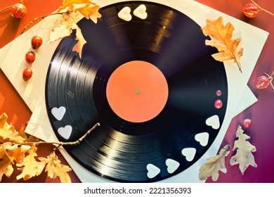 Vintage Vinyl Record In Paper Sleeves On Paper. Golden Yellow Oak Leaves On Orange, Magenta Paper Background With Autumn Decorations. Vintage Retro Music Collection Concept.