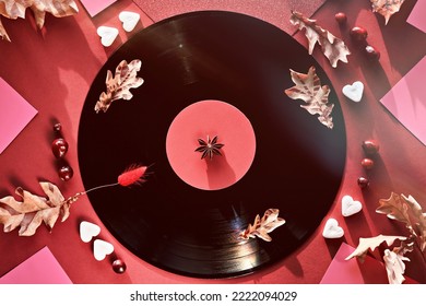 Vintage Vinyl Record In Paper Sleeves On Paper. Yellow Oak Leaves On Red Paper Background With Autumn Decorations. Sugar Hearts, Cranberry Berry. Vintage Retro Music.