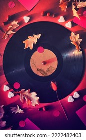 Vintage Vinyl Records In Paper Sleeves On Black Background And Paper Sleeves. Yellow Oak Leaves On Red Paper Background With Autumn Decorations. Sugar Hearts, Cranberry Berry. Vintage Retro Music.