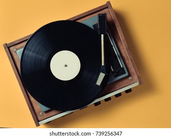 Vintage vinyl turntable with vinyl plate on a yellow pastel background. Entertainment 70s. Listen to music. Top view. - Shutterstock ID 739256347