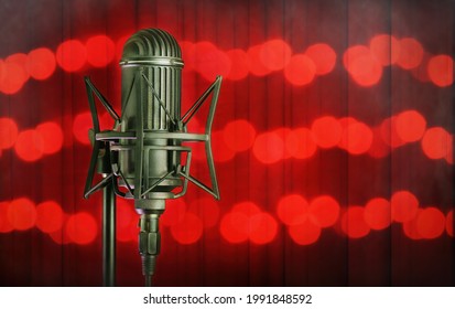 Vintage vocal microphone in a dark theater with a red curtain and spotlight flashes. A celebrity music concept composition