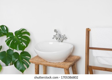Vintage Washbasin With Wooden Towel Rack And Green Plant