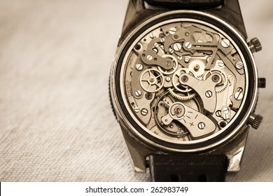 Vintage watch showing it's complex movement and parts. In sepia tone for mood.
