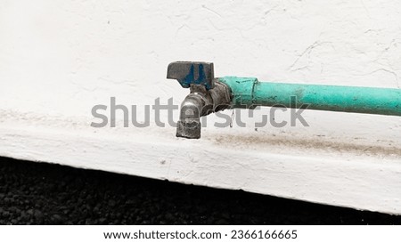 A vintage water faucet on the white wall 