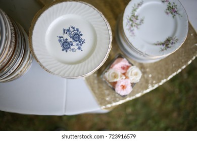 Vintage Wedding Decor Mismatched China On A Table With Flowers And Champagne Gold Sparkly Runner