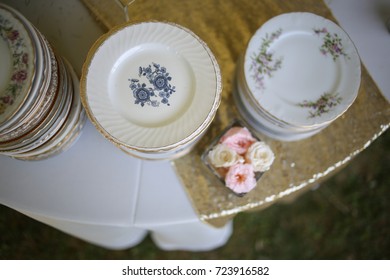 Vintage Wedding Decor Mismatched China On A Table With Flowers And Champagne Gold Sparkly Runner