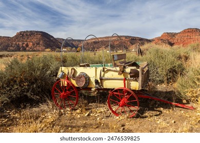 Vintage Wild West Horsedrawn Pioneer Wagon Wheel Cart Relic Model.  American Southwest Western Prairie Mountains Landscape Background, Utah USA - Powered by Shutterstock