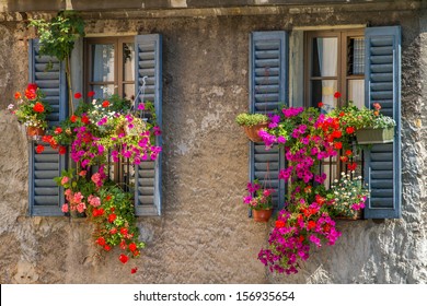 Vintage windows with open wooden shutters and fresh flowers - Powered by Shutterstock