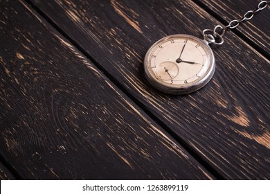 Vintage wise old historical clock on  dark wooden table rough background with space for text. - Shutterstock ID 1263899119