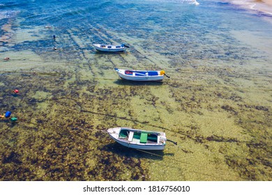 Vintage Wooden Boat In Coral Sea. Boat Drone Photo. Fishing Boats In Clear Turquoise Ocean, Top View. Small Fishing Boat Moored In Blue Clean Transparent Water. Aerial View. Peniche, Portugal.