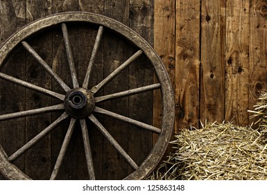 Vintage wooden carriage wheel, straw and wood background