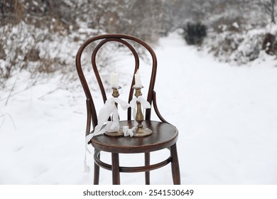 Vintage wooden chair standing outdoors. Winter still life with brass candleholders, silk ribbons. Blurred snow landscape. No people. Christmas festive lifestyle composition - Powered by Shutterstock