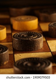 Vintage wooden checkerboard with brown and cream colored checkers. - Shutterstock ID 1909079503