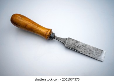 Vintage wooden chisel with wooden handle on white isolate. A hand tool for working with wood. A red - hot blade .