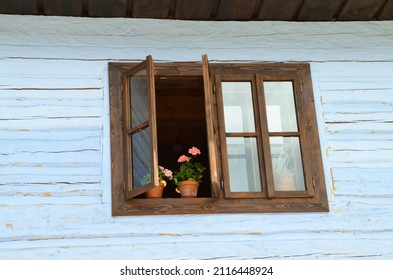 Vintage-Holzhütte - Detail eines offenen Fensters mit Blumentopf