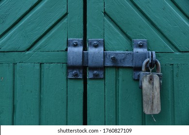 Vintage wooden green doors gates closed with metall padlock with hasp - Powered by Shutterstock
