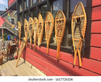 Vintage Wooden Snow Shoes Lined Up Outside A Red House In Canada