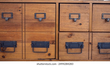 Vintage wooden storage cabinet with multiple small drawers and metal handles, perfect for organizing and adding a rustic touch to any space. solid office that combines durability with artisanal charm - Powered by Shutterstock