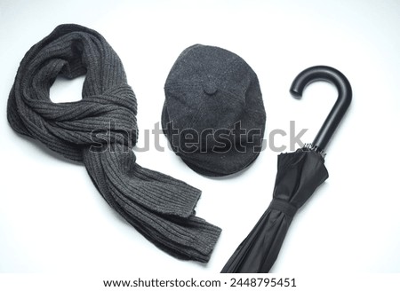 Vintage woolen English eight-piece cap with scarf and umbrella on a white background. Gentleman's accessories