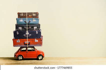 Vintage worn suitcases on retro toy car roof creative travel concept. Copy space - Powered by Shutterstock