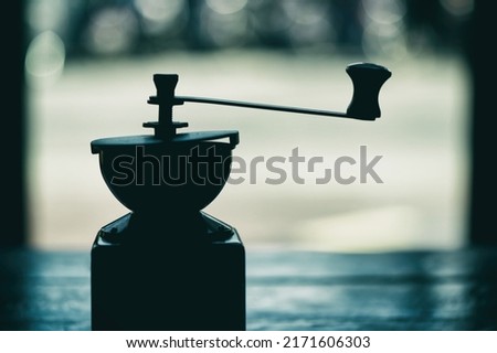 Vintage-style hand crank coffee grinder.
