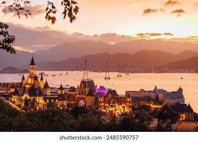 The Vinwonders park (Vinpearl) in Nha Trang, located in Vietnam. The Hon Tre Island. Cable car across the bay and large circumnavigation liner in the distance. Tourist attraction. landscape. Sunset - Powered by Shutterstock