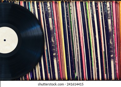 Vinyl record with copy space in front of a collection of albums (dummy titles), vintage process - Shutterstock ID 241614415
