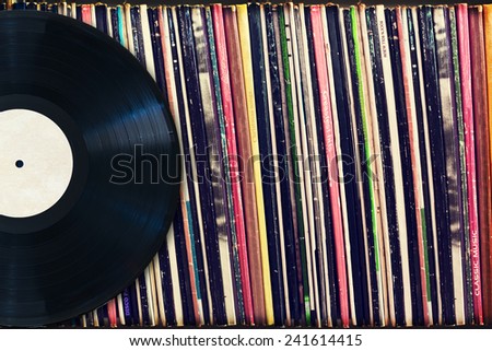 Vinyl record with copy space in front of a collection of albums (dummy titles), vintage process