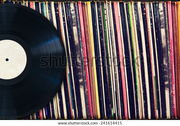 Vinyl record with copy space in\
front of a collection of albums (dummy titles), vintage\
process