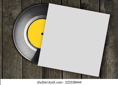 vinyl record with plain white packaging on wood surface
