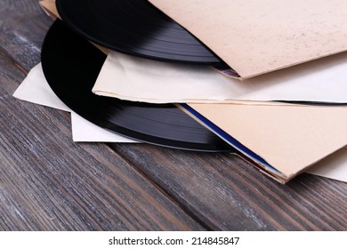 Schallplatten und Papierabdeckungen aus Vinyl auf Holzhintergrund
