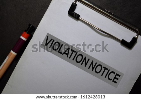 Violation Notice write on a paperwork isolated on black table.