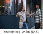 Violence against man on street. Angry man is aggressive, have conflict with young man, holding him by shirt, screaming, threatening him.