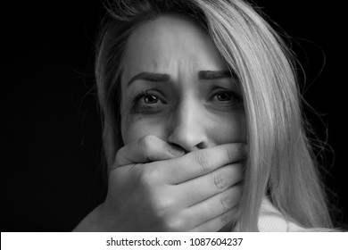 Violence against a woman in the family. A battered girl, a black and white photograph, a man closes his mouth, smothers, does not let you say
