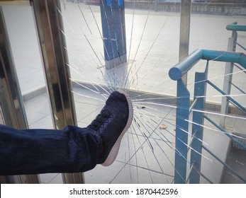 A violent male, boy, man, vandal,angry person breaks and destroys a window with a punch