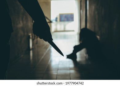Violent man carries a knife attempting to attack a young woman in front of the room.Domestic violence problems.Violence problem women Concept.