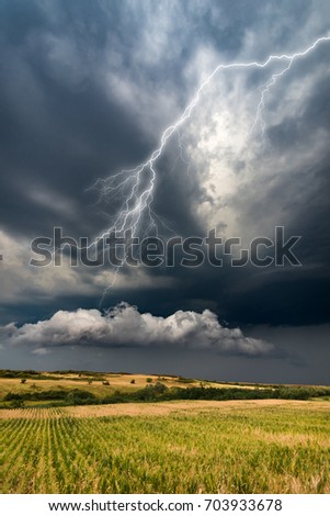 Violent super cell thunderstorm, very bad and dark clouds, lightning storm, hill, vineyard, houses