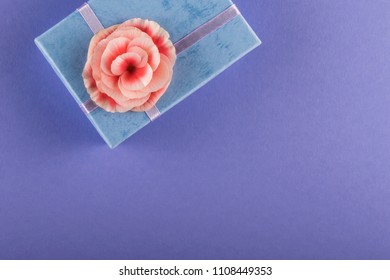 Violet Background With Blue Gift Box And Pink Begonia Flower