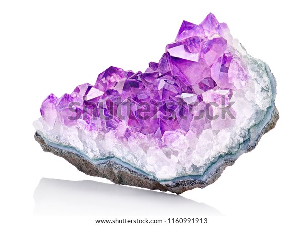 Violet Crystal Stone\
macro mineral. Purple rough Amethyst quartz crystals geode on white\
background, Uruguay
