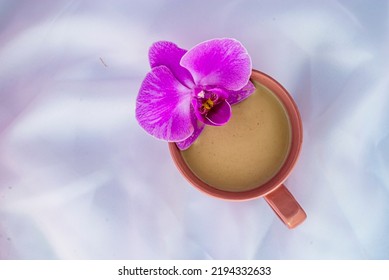 Violet Orchid Flower Pink Cup Of Latte Coffee With Milk White Tulle  Wood Background, Top View Flatlay Morning