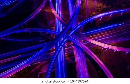 Violets , purples , and blues aerial drone straight down angle above highways and interchange overpass , a travel destination transportation Infrastructure new technology future scene