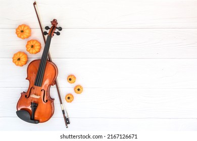 Violin, Bow And Pumkin On White Wood Background. Flat Lay, Top View, Copy Space. Concept Of Classical Music And Autumn, Bowed String Musical Instrument