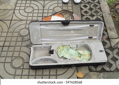 Violin case with paper money and coins on street (Street music) 