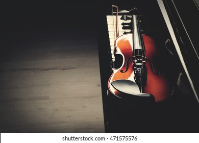 Violin lying on piano keys, close up