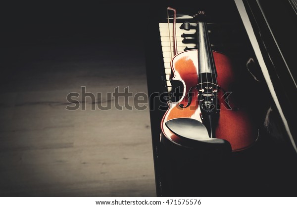 Violin lying on piano keys,\
close up