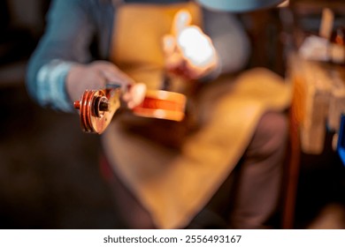 Violin maker working on a violin scroll in his workshop, using tools and precision