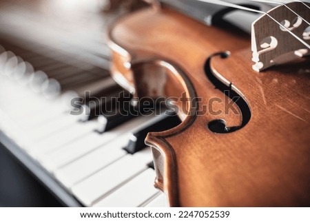 Violin on top of piano keyboard background with copy space for music concept